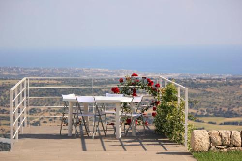 a table and chairs on a balcony with flowers at Villa Zenit in Pozzallo