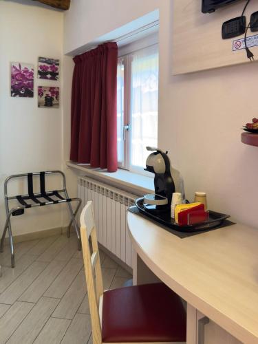 a kitchen with a counter with a table and a chair at BelSorrisoVarese - Elegance City Residence Private Parking -Reservation Required- in Varese
