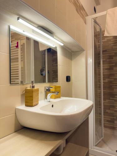 a bathroom with a sink and a mirror at BelSorrisoVarese - Elegance City Residence Private Parking -Reservation Required- in Varese