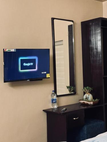 a television on a wall in a room with a mirror at Venice villa varkala cliff -luxurious rooms and apartments in Varkala