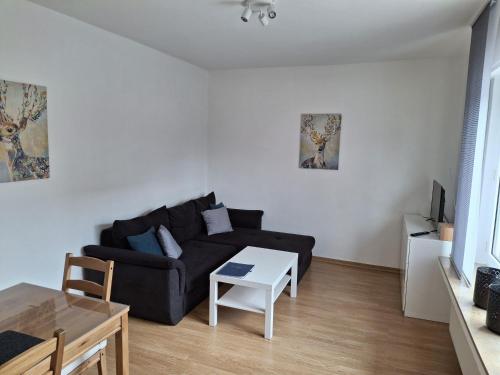 a living room with a black couch and a table at Nelke63 in Nordhorn