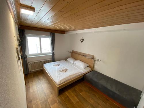 a small bedroom with a bed and a window at Pension Tyrol Maria Alm in Maria Alm am Steinernen Meer