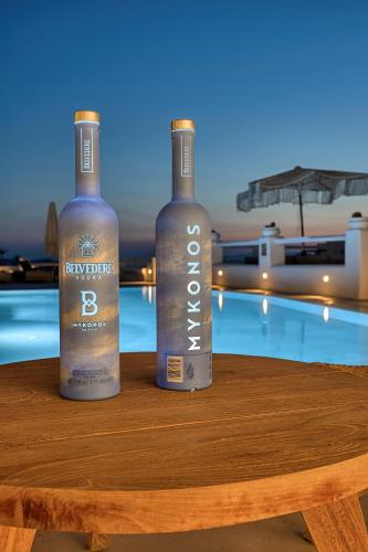two bottles of wine sitting on a table next to a pool at Paolas Sunset in Agios Stefanos