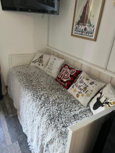 Una cama con almohadas en una habitación. en Bienvenue chez nous, en Arc 2000