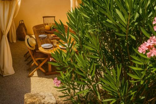 une table et des chaises de salle à manger avec des plantes et des fleurs dans l'établissement Ejoki, à Sarlat-la-Canéda