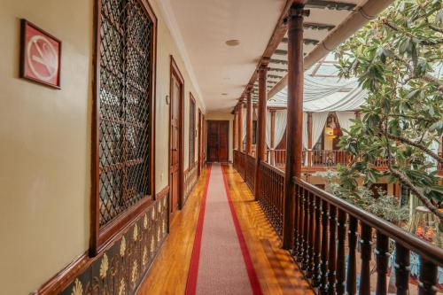 a corridor of an old building with a red carpet at Hotel Boutique Santa Lucia in Cuenca