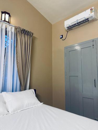 a bedroom with a bed and a air conditioner on the wall at Venice villa varkala cliff -luxurious rooms and apartments in Varkala