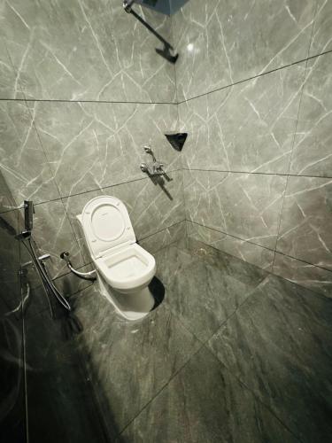 a bathroom with a white toilet in a wall at Venice villa varkala cliff -luxurious rooms and apartments in Varkala