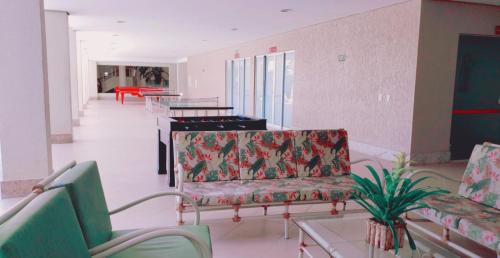a living room with two chairs and a piano at Hot Springs Piscinas 24horas - Central de Reservas in Caldas Novas
