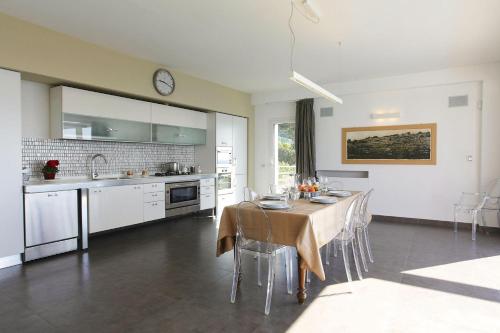 a kitchen and dining room with a table with chairs at Villa Zenit in Pozzallo