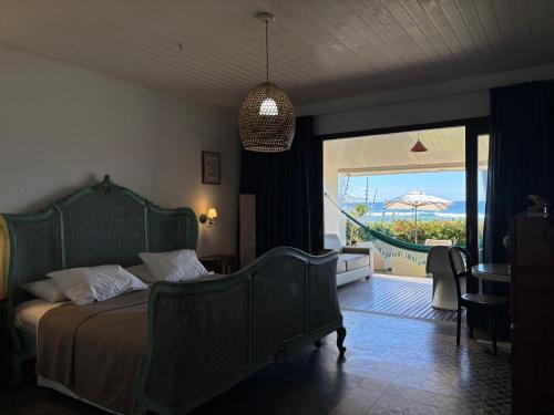 a bedroom with a bed and a view of the ocean at Pousada a Capela in Arembepe