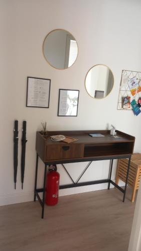 a desk with two mirrors on the wall and a red trash can at Lorimare in Marina di Massa