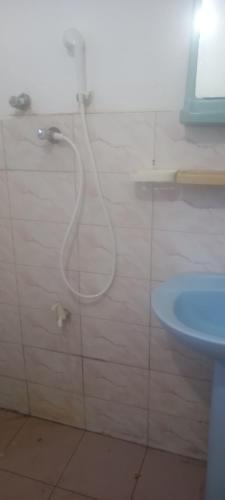 a shower with a hose in a bathroom with a sink at Crown Majesty in Arugam Bay