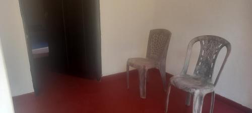 two chairs sitting in a room with a tv at Crown Majesty in Arugam Bay