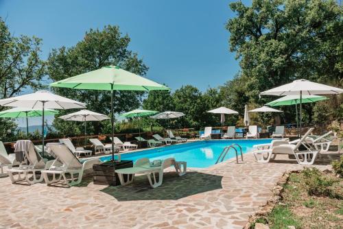 a swimming pool with chairs and umbrellas and a pool at Al Podere del Nonno Romolo in Sansepolcro