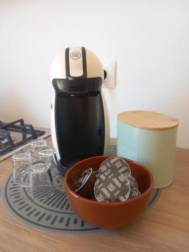 a coffee maker on a table with a bowl of cookies at Lorimare in Marina di Massa