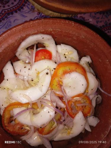 a bowl of food with onions tomatoes and onions at Villu Villa in Anuradhapura