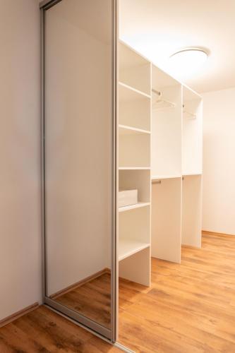a glass partition in a room with wooden floors at Comfort 2BR Apartment Piešťany in Piešťany