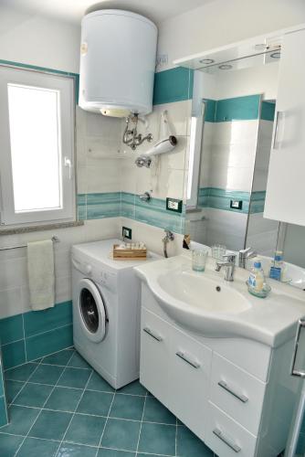 a bathroom with a washing machine and a sink at Casetta Achille, Ischia-Napoli in Ischia