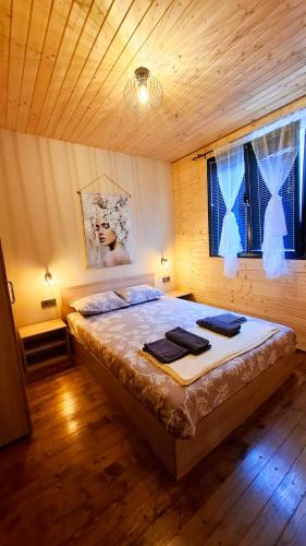 a bedroom with a large bed in a wooden room at Еко Къщи Градина in Sozopol