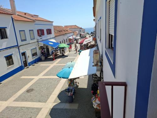 a view of a street with umbrellas and buildings at Casa Areia - Porto Covo in Porto Covo