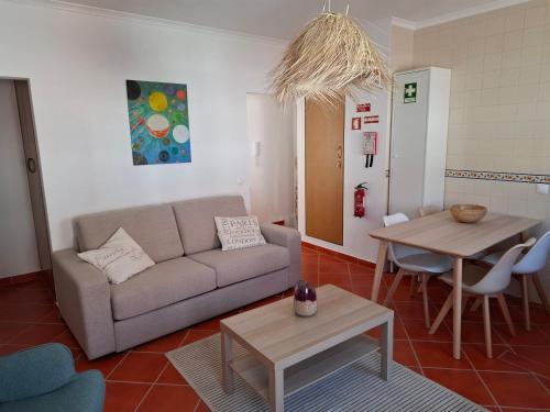 a living room with a couch and a table at Casa Areia - Porto Covo in Porto Covo