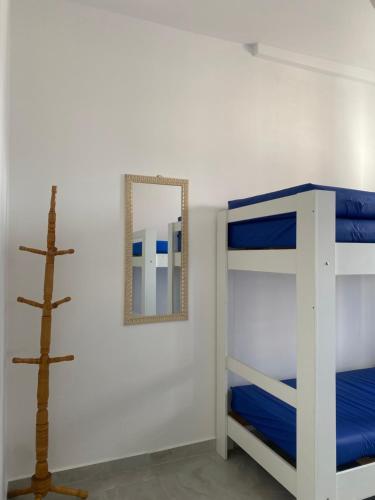 ein Schlafzimmer mit Etagenbetten und einem Spiegel in der Unterkunft Apto da Sol - 200m da Praia, Estacionamento e Wi-Fi in Praia Grande