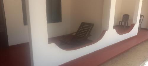 a black chair sitting on a wall in a room at Crown Majesty in Arugam Bay