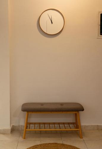 a clock hanging on a wall with a bench at Aristoteluos By the Sea in Thessaloniki