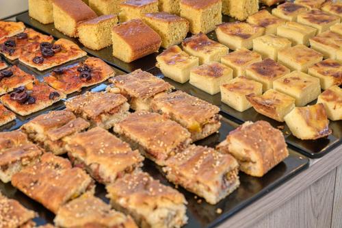 a bunch of different types of cakes on a display at Paolas Sunset in Agios Stefanos