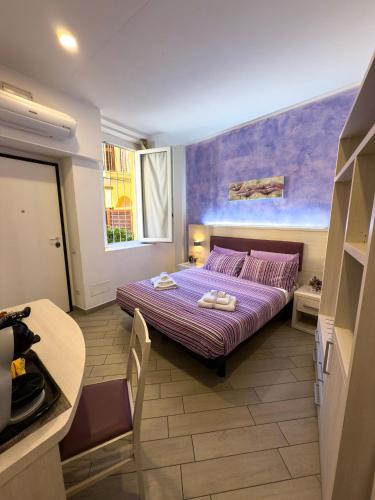 a bedroom with a purple bed and a table at BelSorrisoVarese - Elegance City Residence Private Parking -Reservation Required- in Varese
