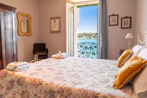 a bedroom with a large bed with a large window at Victoria Palace in Salò