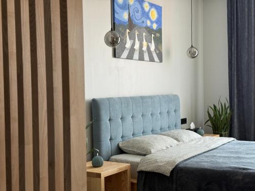 a bedroom with a blue bed and a couch at «ГОРИ́ЩЕ на площі Польський ринок» in Kamianets-Podilskyi