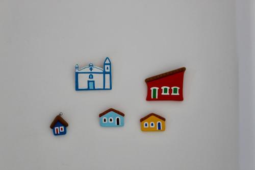 a group of small houses on a white wall at Pousada a Capela in Arembepe