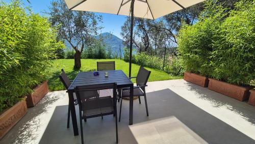 a table and chairs with an umbrella on a patio at La Giulia Suites like Home in Bonassola