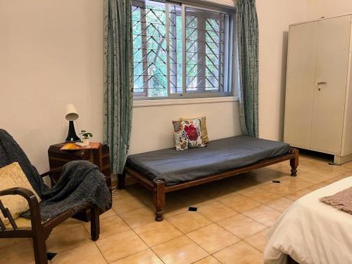 a room with a bench and a window and a chair at Beautiful Villa in Khandala with Hot Tub in Lonavala