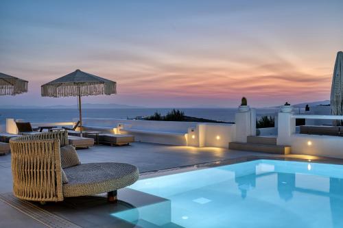 a villa with a swimming pool at dusk at Paolas Sunset in Agios Stefanos