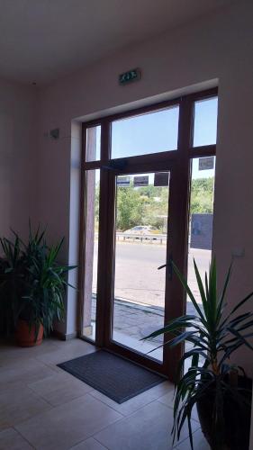 Una puerta abierta en una habitación con plantas en macetas. en Студио Аглая, en Varna