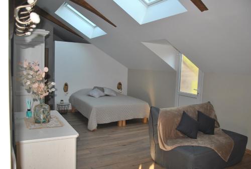 a attic bedroom with a bed and a chair at Domaine de Grisere in Tilh