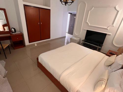 a bedroom with two beds and a television in it at Hotel La Roche in Brazzaville