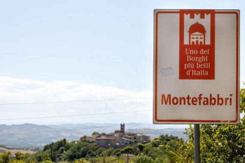 a sign in front of a mountain at Italian Experience-La Pineta Holiday Homes in Monte Fabbri