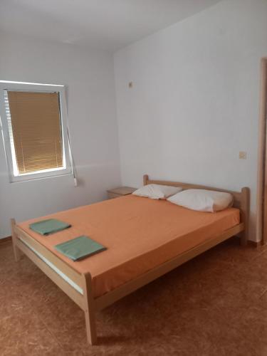 a bedroom with a bed in a room with a window at Apartmani Stojanović in Sutomore