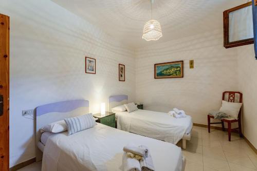 a hospital room with two beds and a chair at Italian Experience-La Pineta Holiday Homes in Monte Fabbri