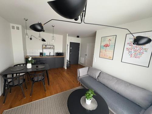a living room with a couch and a table at Apartament TULIP Chełmońskiego Śrem in Śrem