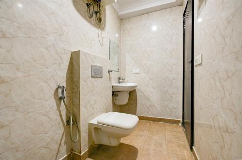 a bathroom with a toilet and a shower and a sink at Hotel Ark Suites At Airport in New Delhi