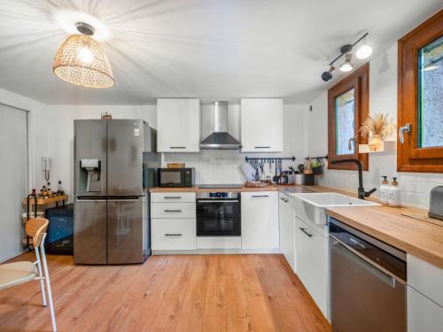 a kitchen with white cabinets and stainless steel appliances at Villa Horizon - 5min from Monaco - Panoramic view - Infinity Pool - Air conditionner - Garden - Parking - Premium Services - Near Monaco Events in Fontvieille