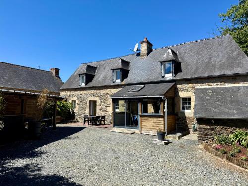 ein altes Steinhaus mit Garage davor in der Unterkunft maison bretonne,gîte de keranglaz in Ploubezre