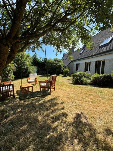 a yard with two park benches and a swing at Maison trois chambres en impasse in Saint-Martin-des-Champs