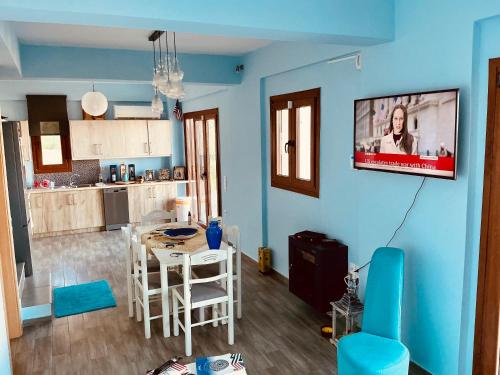 a living room with a table and a tv on the wall at Villa Christoforos Kekakos Magical View in Neapolis