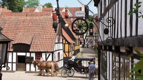 a horse drawn carriage on a street in a village at Central apartment with parking and Netflix in Aarhus